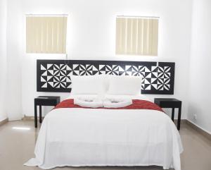 a bedroom with a white bed with two tables at "Best View Hotel & Apartments" in Nadi