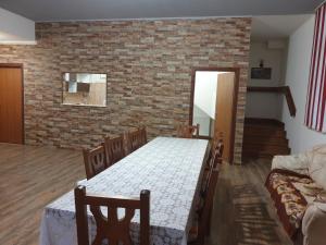 a dining room with a table and a brick wall at Casa Alin Poiana Mărului in Poiana Mărului