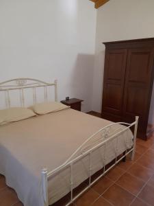 1 dormitorio con 1 cama y armario de madera en Villa Paradiso, en Montegiordano