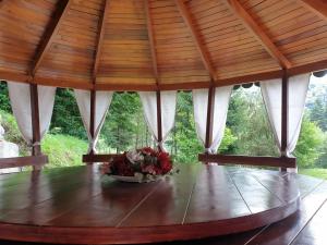 a table in a pavilion with a bowl of flowers on it at Casa Alin Poiana Mărului in Poiana Mărului