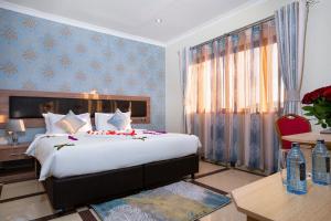 a bedroom with a large bed in a room with blue walls at West Lerruat Hotel in Nairobi +33 photos