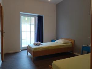 niewielka sypialnia z łóżkiem i oknem w obiekcie Holiday Home with free parking by the beach w Breli