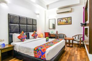 a hotel room with a bed and a table and chairs at FabHotel Cameron in New Delhi