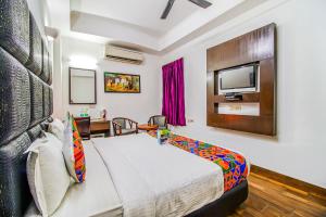 een hotelkamer met een bed en een televisie bij FabHotel Cameron in New Delhi