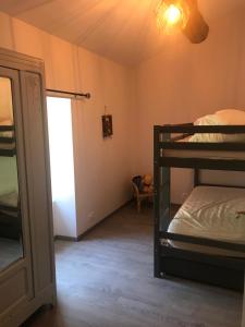 Zimmer mit 2 Etagenbetten und einem Spiegel in der Unterkunft Le grenier de l Aigoual in Valleraugue