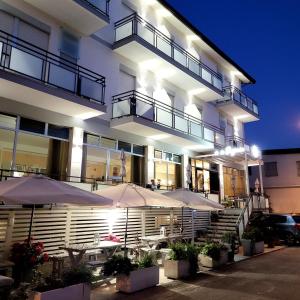 ein Gebäude mit Sonnenschirmen in der Nacht davor in der Unterkunft Hotel Eugenio in Rimini