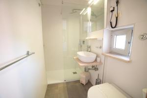 a white bathroom with a sink and a toilet at Hotel Villa A Mare in Rodi Garganico +109 photos