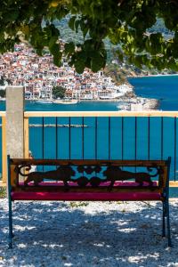 un banco sentado bajo un árbol con vistas a la ciudad en Irene' s Paradise, en Skopelos Town