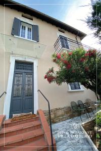 una casa con una puerta azul y algunas sillas en Villa Gaffurio, en Bérgamo