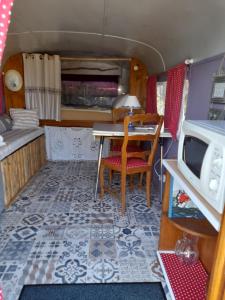 uma cozinha em miniatura e sala de jantar numa caravana de brinquedos em le clos des epinettes em Angé