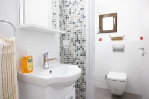 a white bathroom with a sink and a toilet at Bellapais Apartments in Kyrenia +32 photos