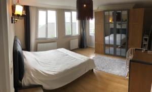 1 dormitorio con 1 cama blanca en una habitación con ventanas en Large private villa en Arnavutköy