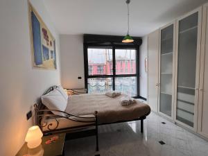 - une chambre avec un lit et une grande fenêtre dans l'établissement JOIVY Oreste s Apartment, à Gênes