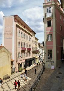 um grupo de pessoas andando por uma rua com edifícios em Casa Borges em Coimbra