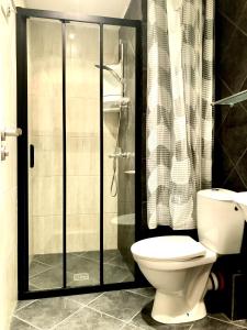 a bathroom with a toilet and a glass shower at Lovely 1BD Apartment in a Luxury Resort in Sozopol in Sozopol