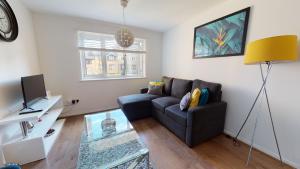 a living room with a couch and a tv at Jdb West Ham 2-Bedroom with parking in London