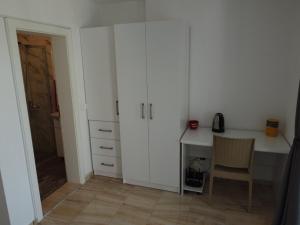 Dieses weiße Zimmer verfügt über einen Schreibtisch und einen Stuhl. in der Unterkunft Villa Dimo Topal in Ohrid