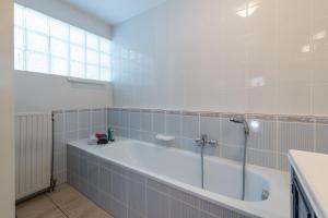 ein großes Badezimmer mit Badewanne und Fenster in der Unterkunft Grimaud 185 - Kustpark Village Scaldia in Hoofdplaat