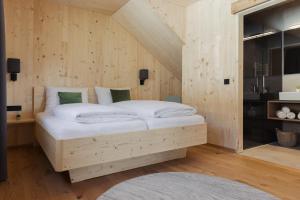a bedroom with a bed in a wooden wall at Chalets Santner in Sankt Jakob in Defereggen +16 photos