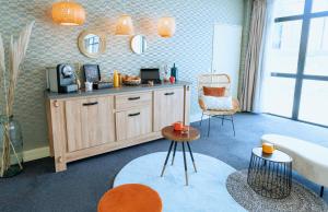 uma sala de estar com uma banheira, uma mesa e cadeiras em Appart'City Confort Toulouse Purpan em Toulouse