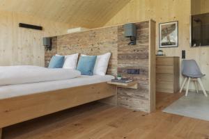 a bedroom with a bed and a wooden wall at Chalets Santner in Sankt Jakob in Defereggen