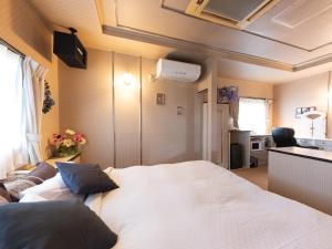 a hotel room with a bed and a window at Tabist Hotel Nizi Fuefuki Misaka in Fuefuki