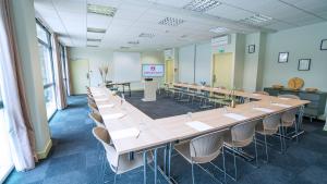 a conference room with tables and chairs and a screen at Appart'City Confort Toulouse Purpan in Toulouse