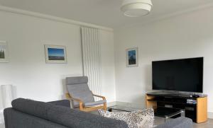 a living room with a couch and a tv at Luxury 2-bedroom apartment near beach in St Andrews in St. Andrews