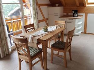 una mesa de madera y sillas en una cocina con ventana en Haus Sigmund, en Oberharmersbach