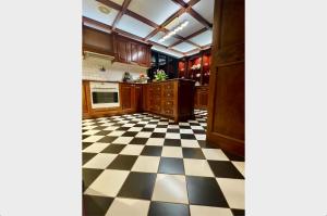 a kitchen with a black and white checkered floor at Fernhill Estate “ Gingerbread House” in Kallista