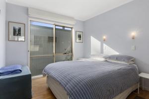 a bedroom with a bed and a large window at Beach Bush and Birds in Lorne