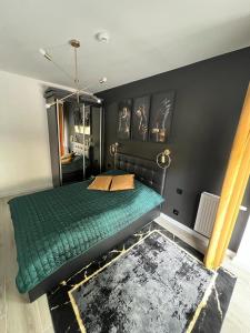 a bedroom with a green bed and black walls at Black Amber in Władysławowo
