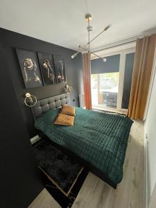 a bedroom with a green bed and a window at Black Amber in Władysławowo