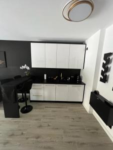 a kitchen with white cabinets and a table in a room at Black Amber in Władysławowo