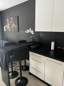 a kitchen with a black counter and white cabinets at Black Amber in Władysławowo