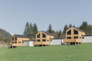 een groep houten huizen in een veld bij Chalets Santner in Sankt Jakob in Defereggen
