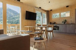 a living room with a table and chairs and a tv at Chalets Santner in Sankt Jakob in Defereggen