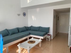 a living room with a blue couch and a table at La Vista Bonita in Corralejo
