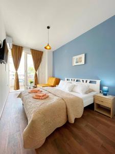 1 dormitorio con 1 cama grande y pared azul en Apartments Lungo Mare Ulcinj, en Ulcinj
