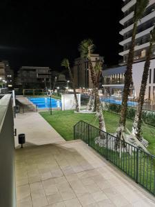 a walkway with palm trees and a pool at night at Apartamento Justina 2 in Los Mártires