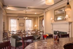 a restaurant with tables and chairs and a fireplace at Middlebury Inn in Middlebury