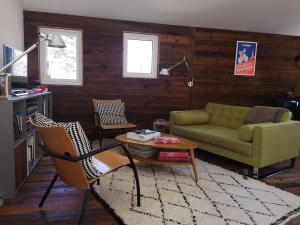 a living room with a green couch and a table at Un chalet au Ventoux - Mont Serein in Mont Serein