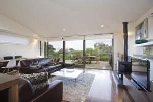 a living room with a couch and a table at Beachside At Breakers in Lorne