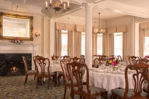 a dining room with a table and chairs and a fireplace at Middlebury Inn in Middlebury