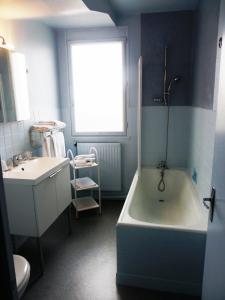 レ・サ​​ーブル・ドロンヌにあるHôtel Du Portの青いバスルーム(バスタブ、シンク付)