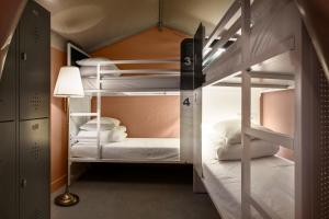 a bunk bed room with two bunk beds and a lamp at Urban Camper Hostel & Bar in Copenhagen