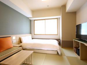 a bedroom with a bed and a window and a television at Onyado Nono Sendai Natural Hot Spring in Sendai