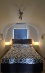a bedroom with a bed with a ceiling fan and lights at Casa Romanzi in Capri