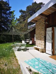 a patio with a bench and a stone building at Un chalet au Ventoux - Mont Serein in Mont Serein