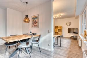 a dining room and living room with a wooden table and chairs at Haus Kleemann E24 in Norderney